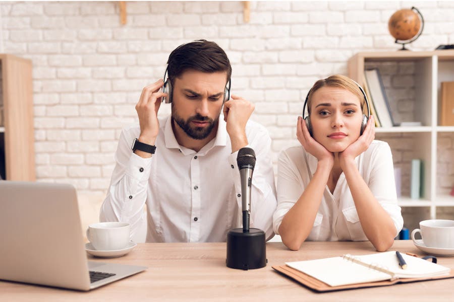 Male and female podcaster looking confused