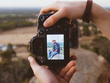 photographer holding camera taking photo of man