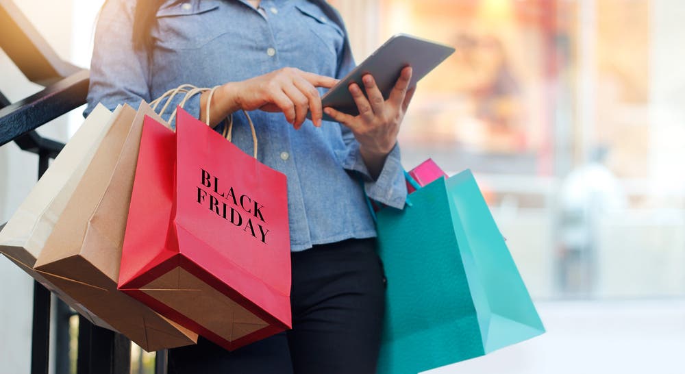 woman holding multiple bags after black friday shopping