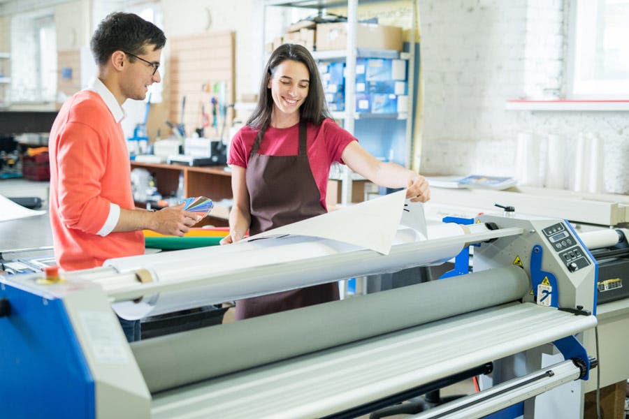 man and woman observing wide format print output