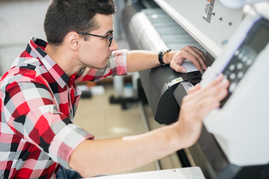 man operating a wide format printer