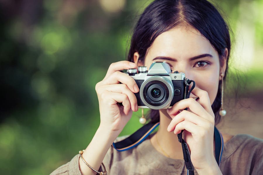 Young woman shooting a picture with a mirrorless camera