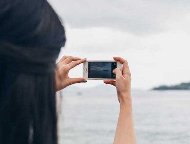 woman taking photo boat