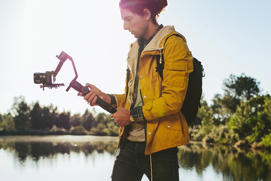 outdoor videographer shooting with a gimbal stabilized mirrorless camera