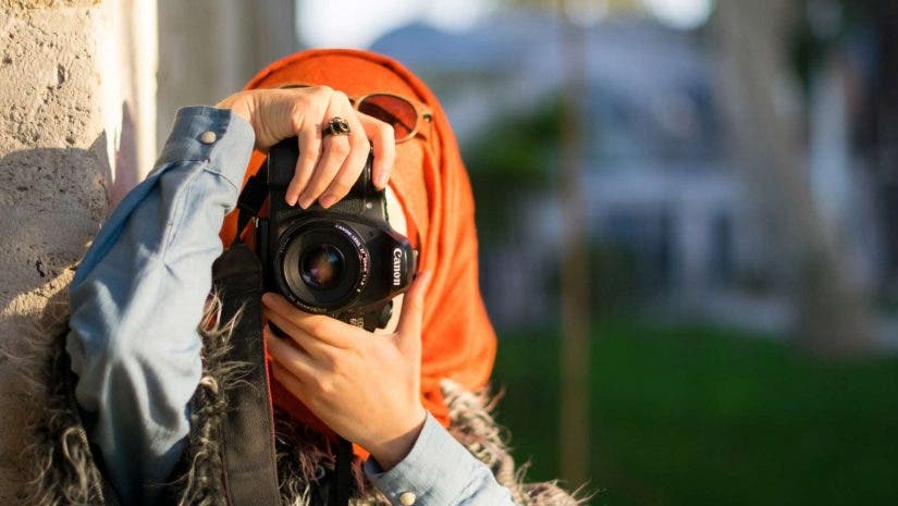 Muslim woman holds a Canon camera