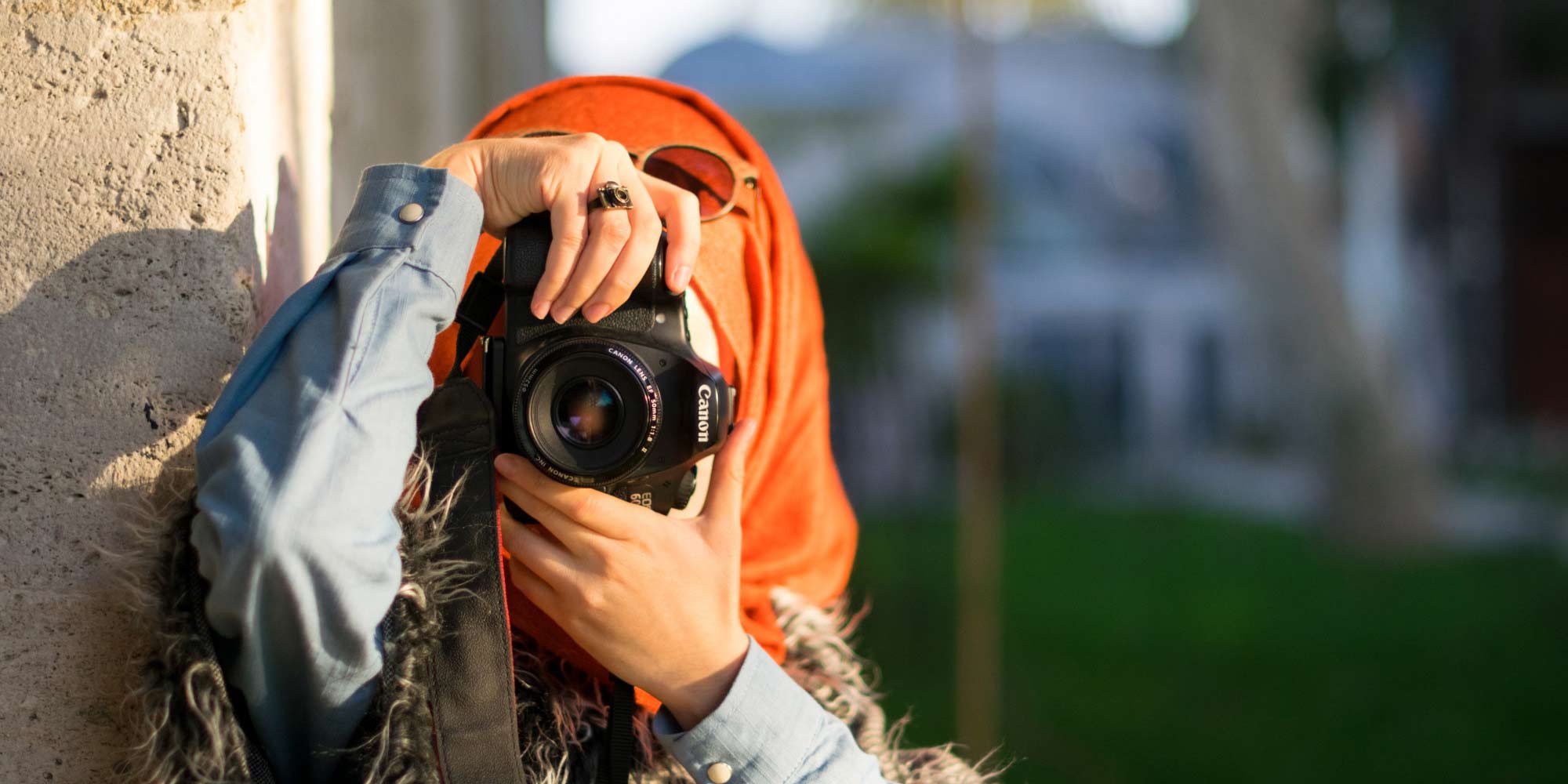 Muslim woman holds a Canon camera