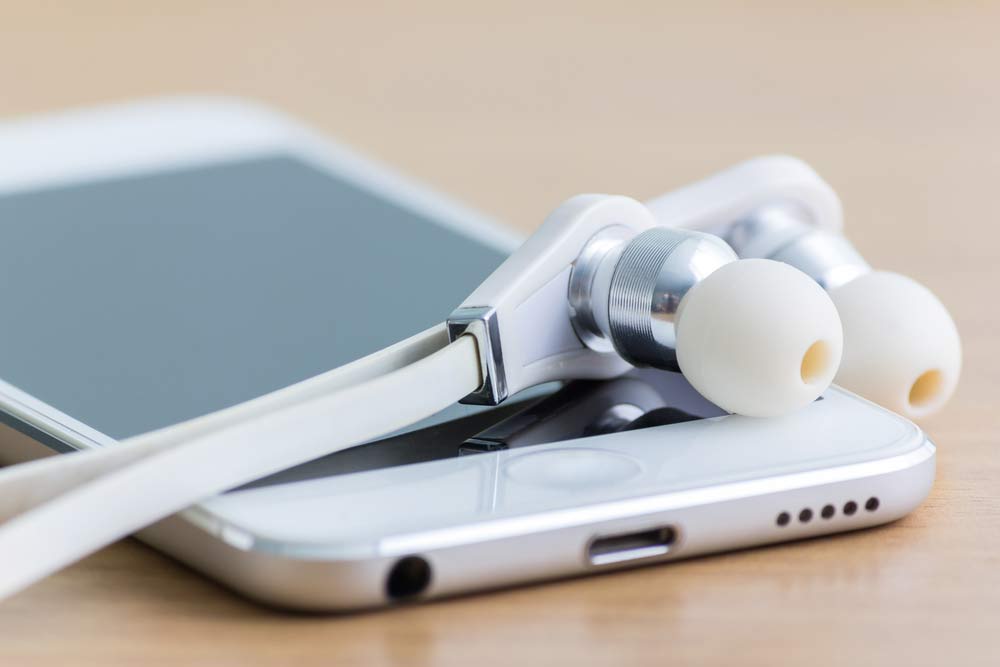 in-ear headphones on top of a smartphone