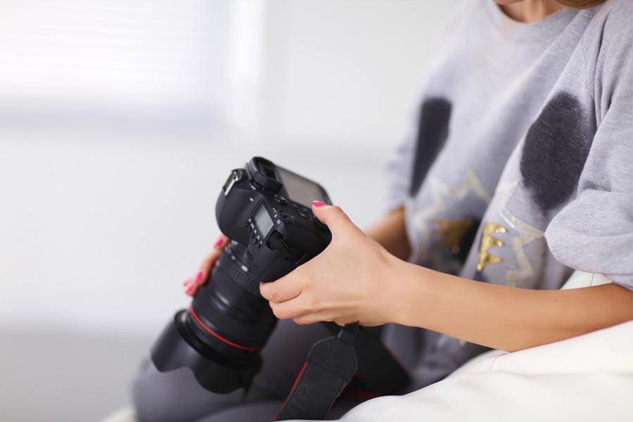 a girl using the controls on a DSLR