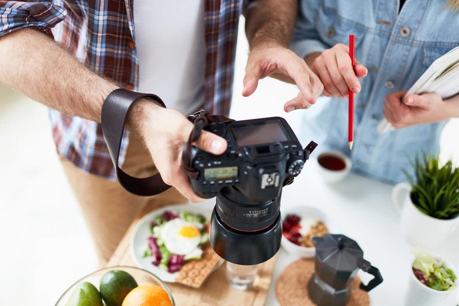 two photographers taking photos of breakfast items