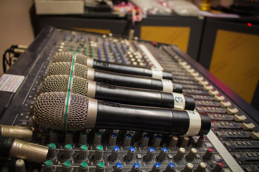 wireless microphones on top of an audio mixer console
