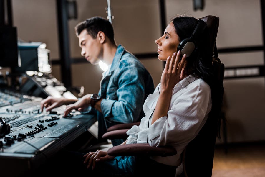 female sound engineer listening to a recording with headphones