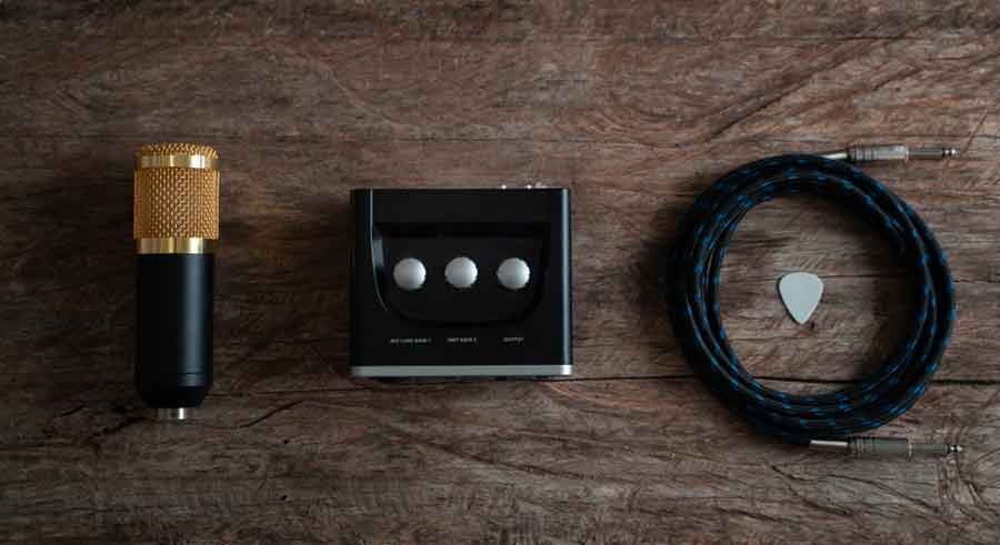 flatlay shot of condenser microphone, standard mic cable, and audio interface