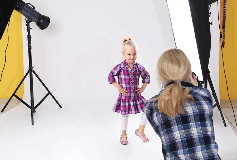 a female photographer taking a little girl’s portrait