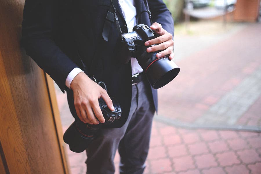 a wedding photographer holding two cameras