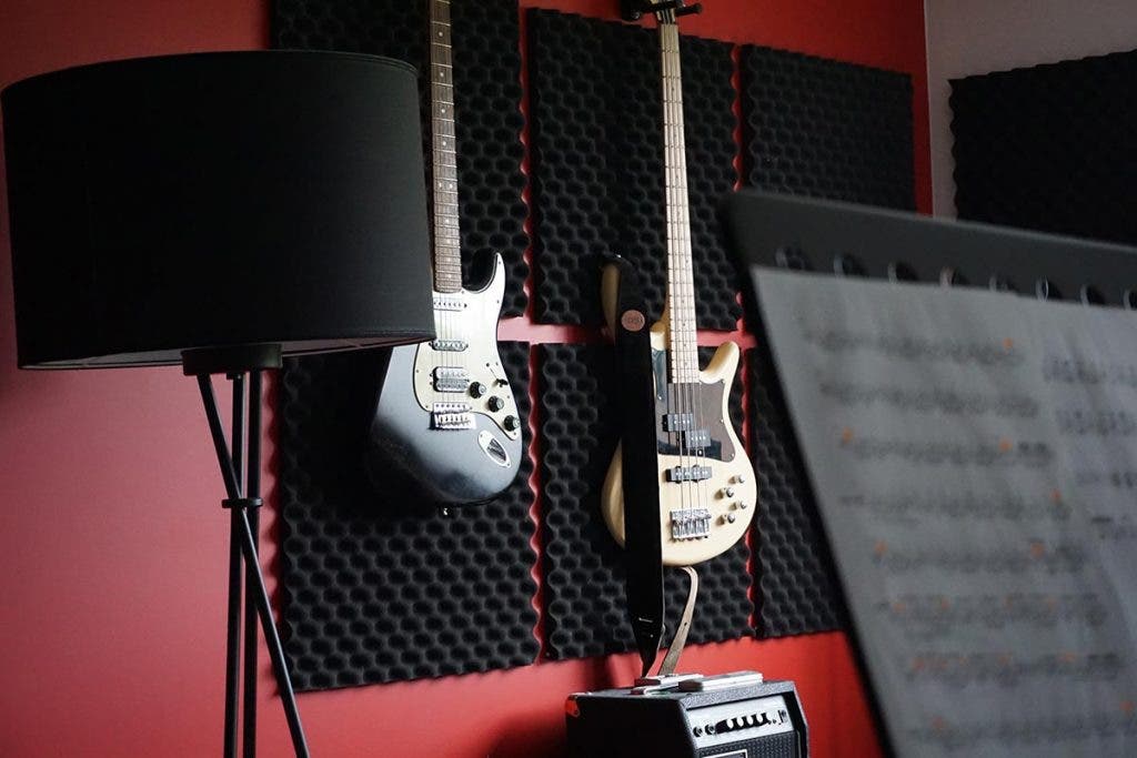 bass guitar and electric guitar on wall in recording studio