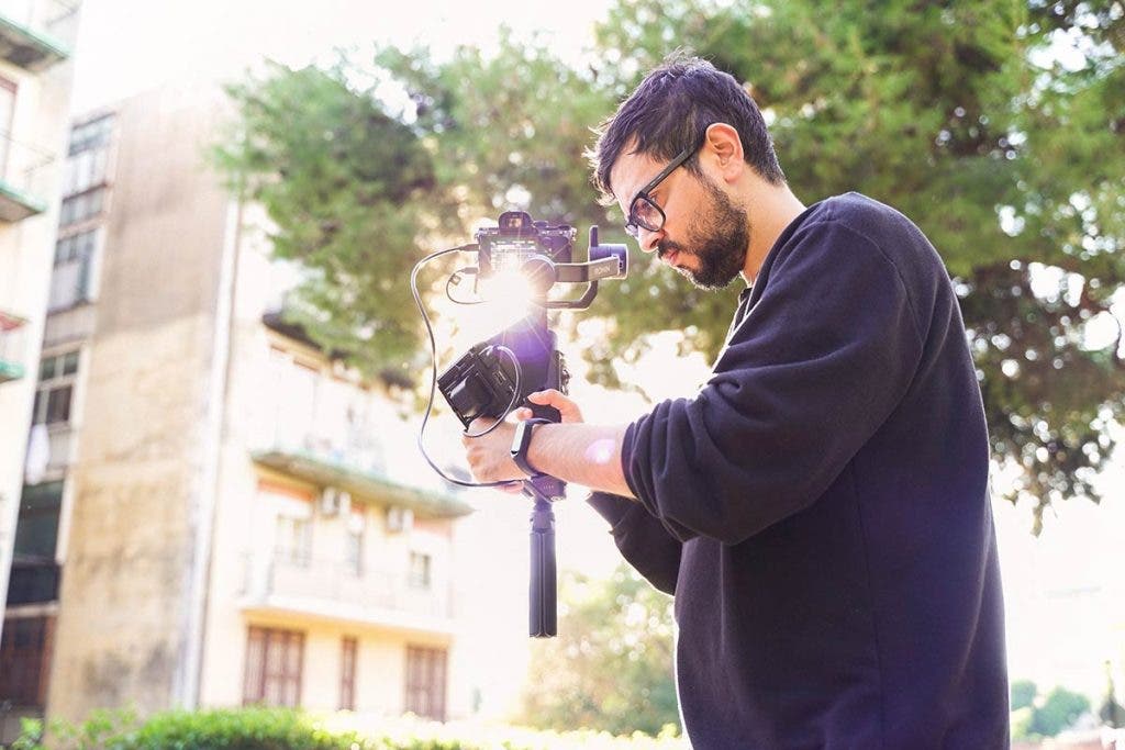 filmmaker recording video with mirrorless camera and gimbal