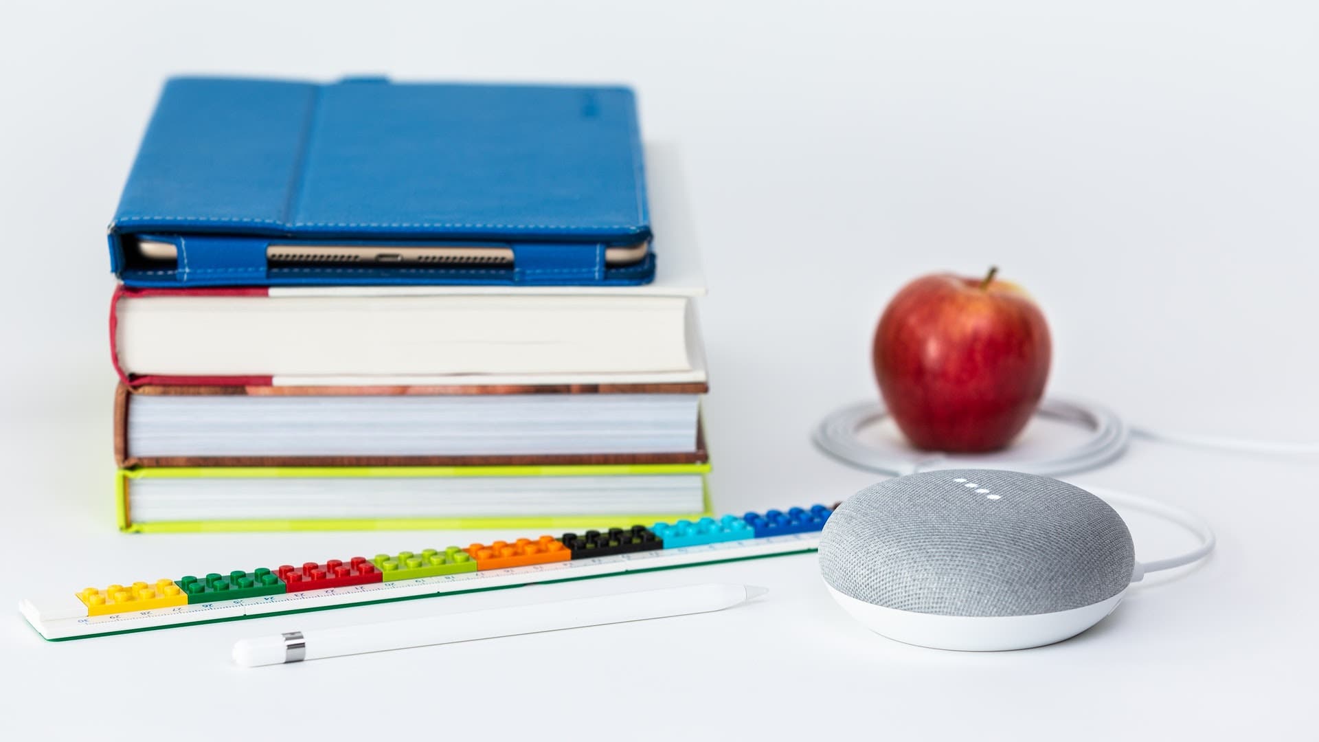 Google Home next to a stack of books