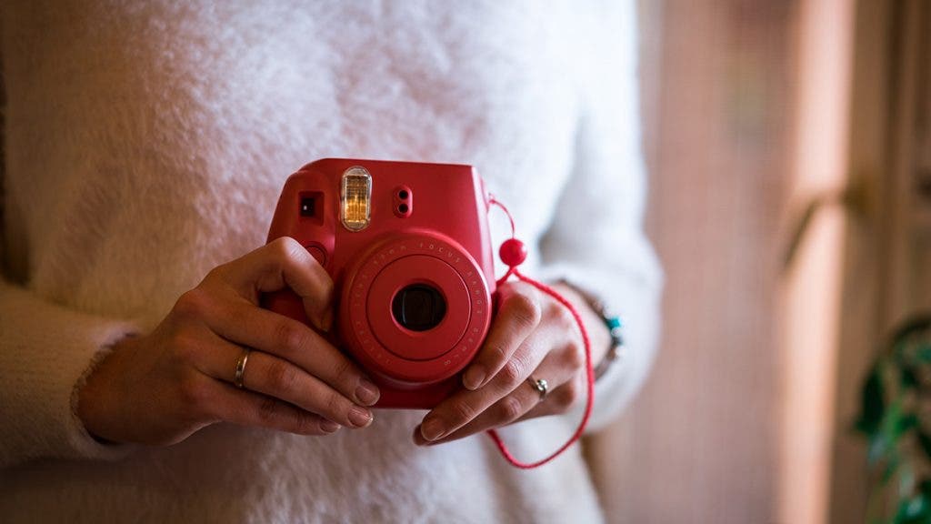 woman holding instant camera