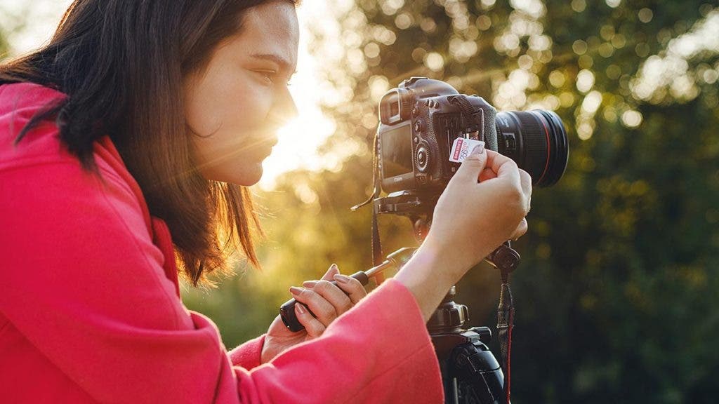 photographer putting in sd card to camera