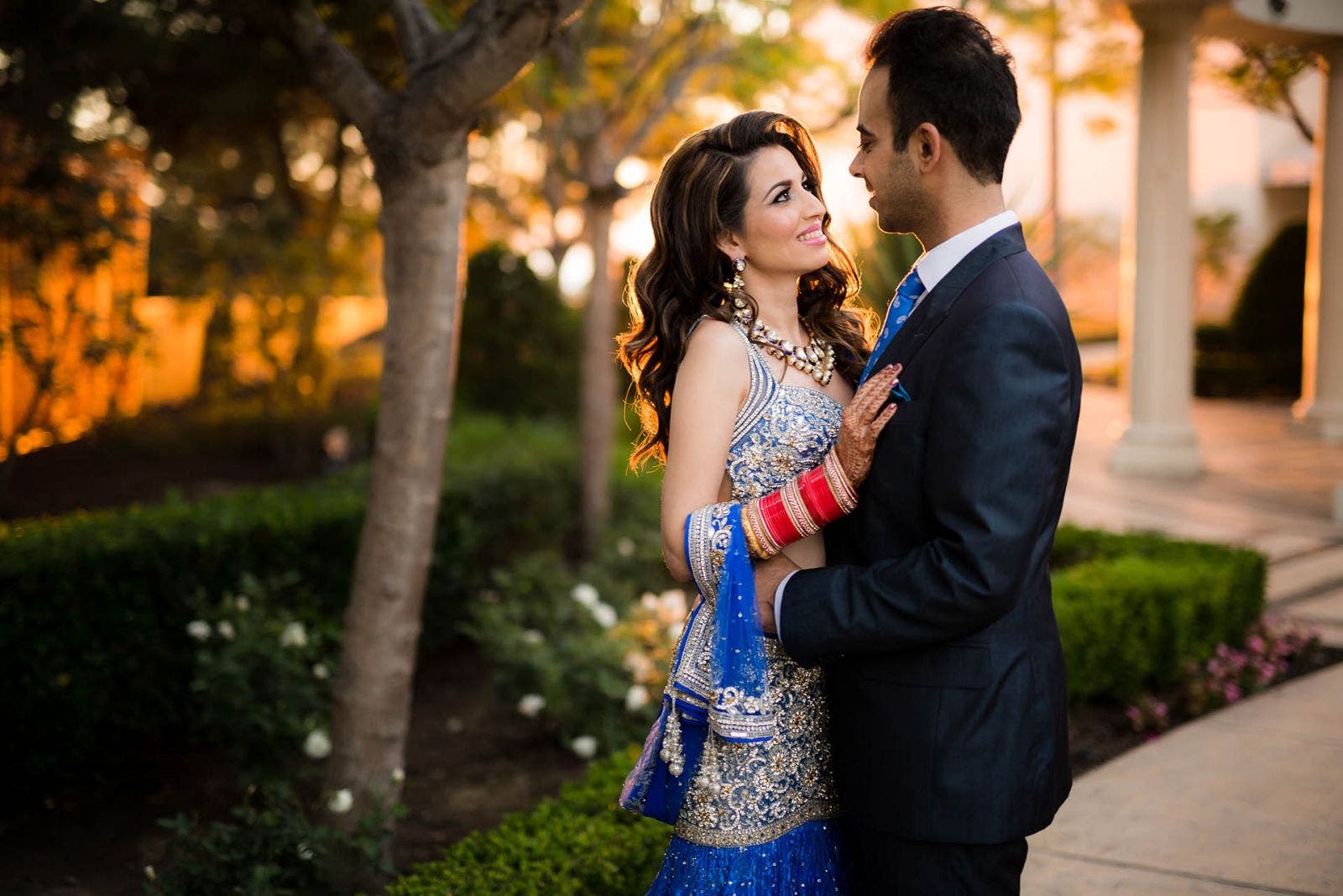 couple poses backlit by off-camera flash to recreate the sun