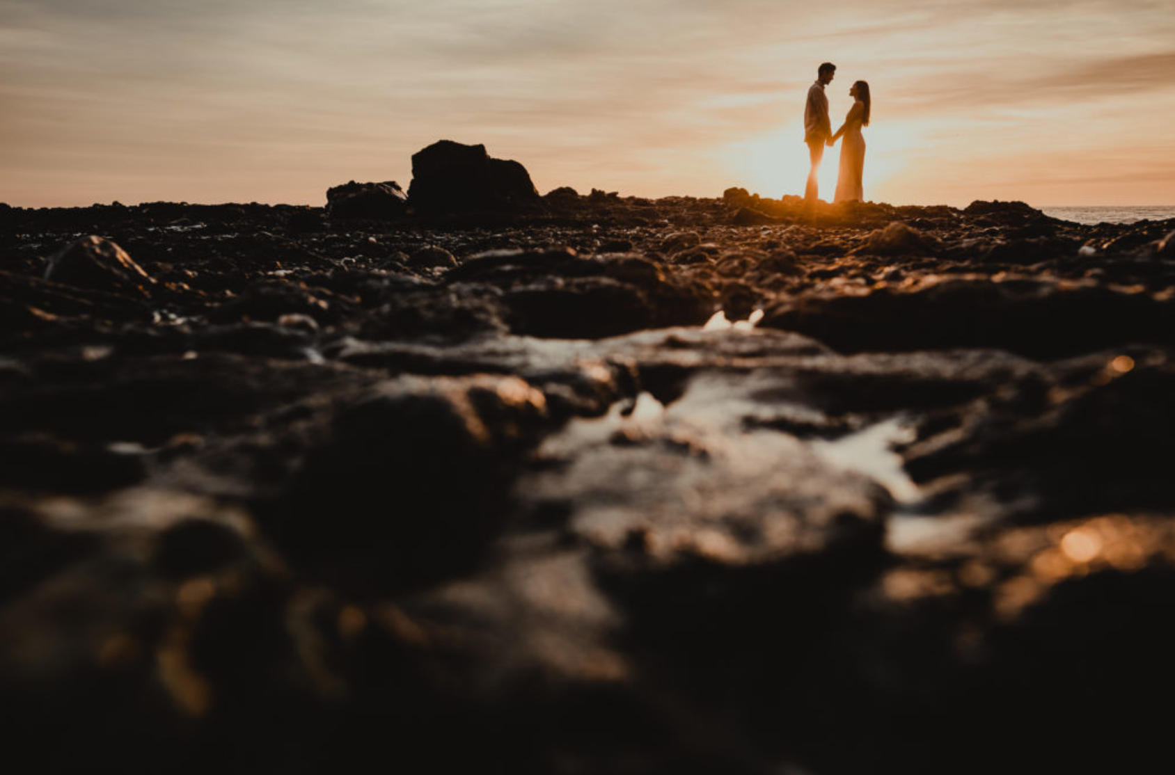 Couple creates silhouette agains golden background