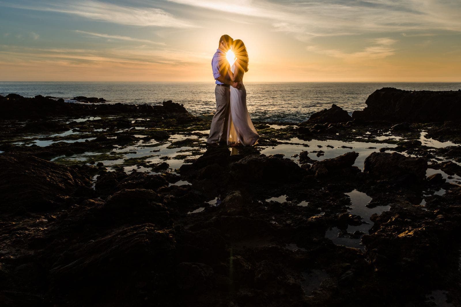 Couple stands on the beach for golden hour photography