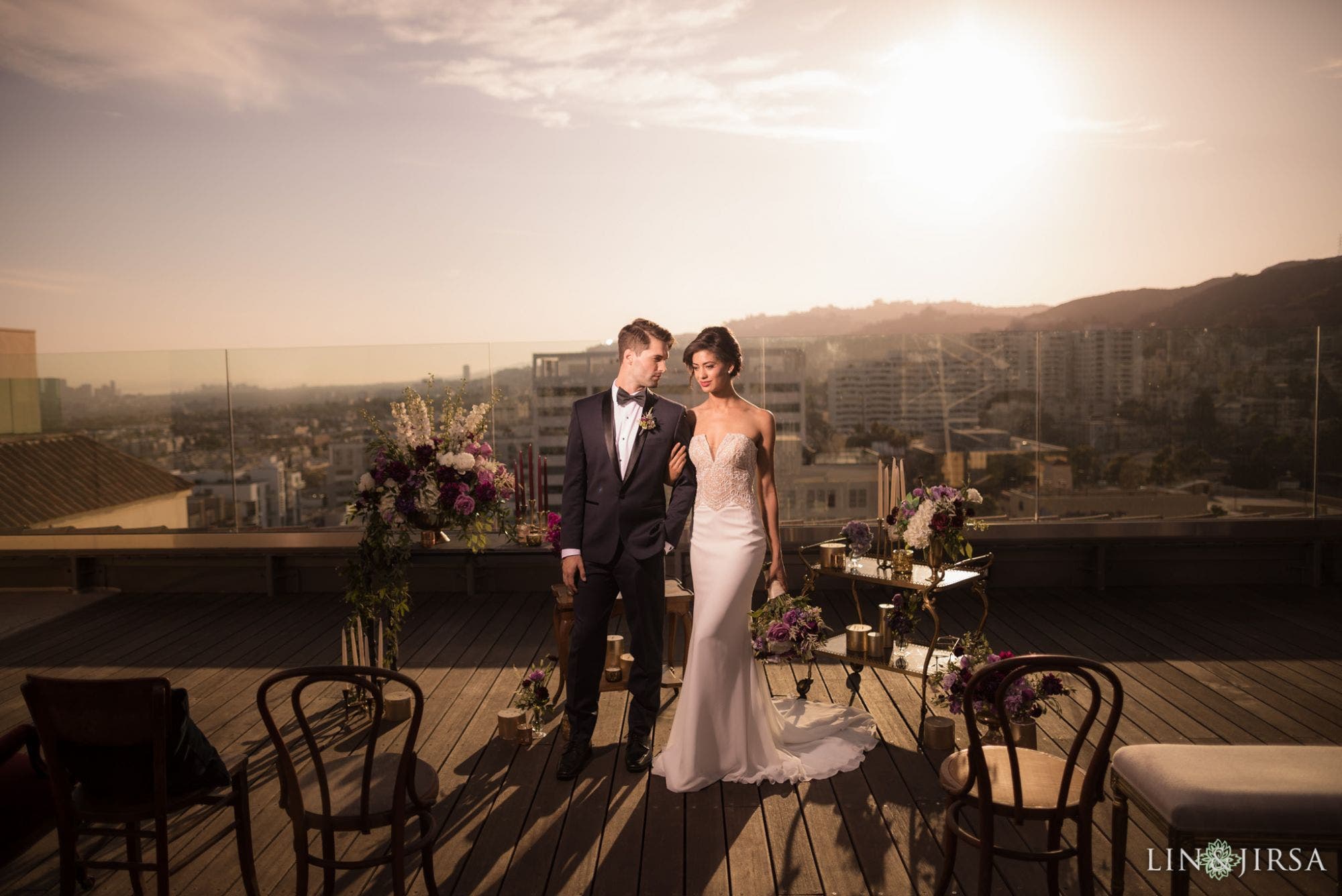 Couple stands on a hotel roof at sunset