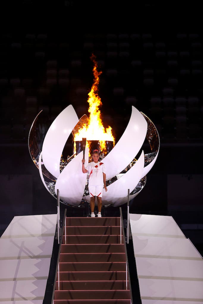 TOKYO, JAPAN - JULY 23: Naomi Osaka of Team Japan lights the Olympic cauldron with the Olympic torch during the Opening Ceremony of the Tokyo 2020 Olympic Games at Olympic Stadium on July 23, 2021 in Tokyo, Japan. (Photo by Jamie Squire/Getty Images)