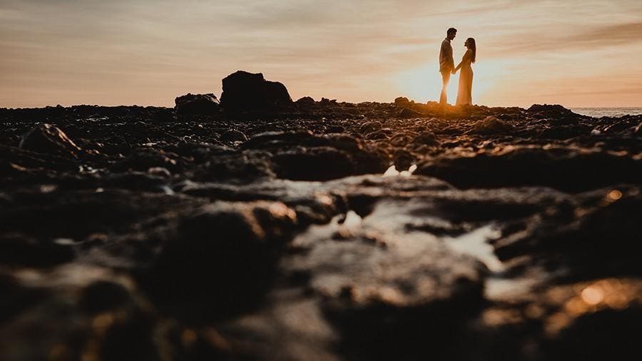 couple pose in front of sunset
