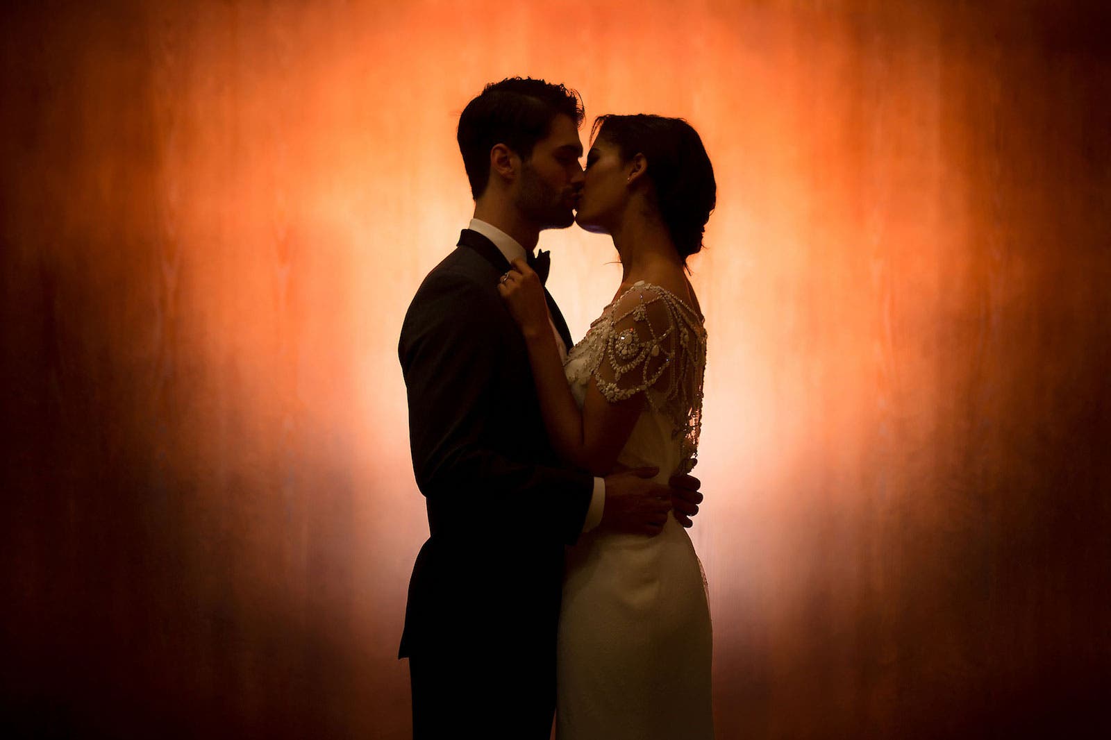Couple pose in front of boring wall