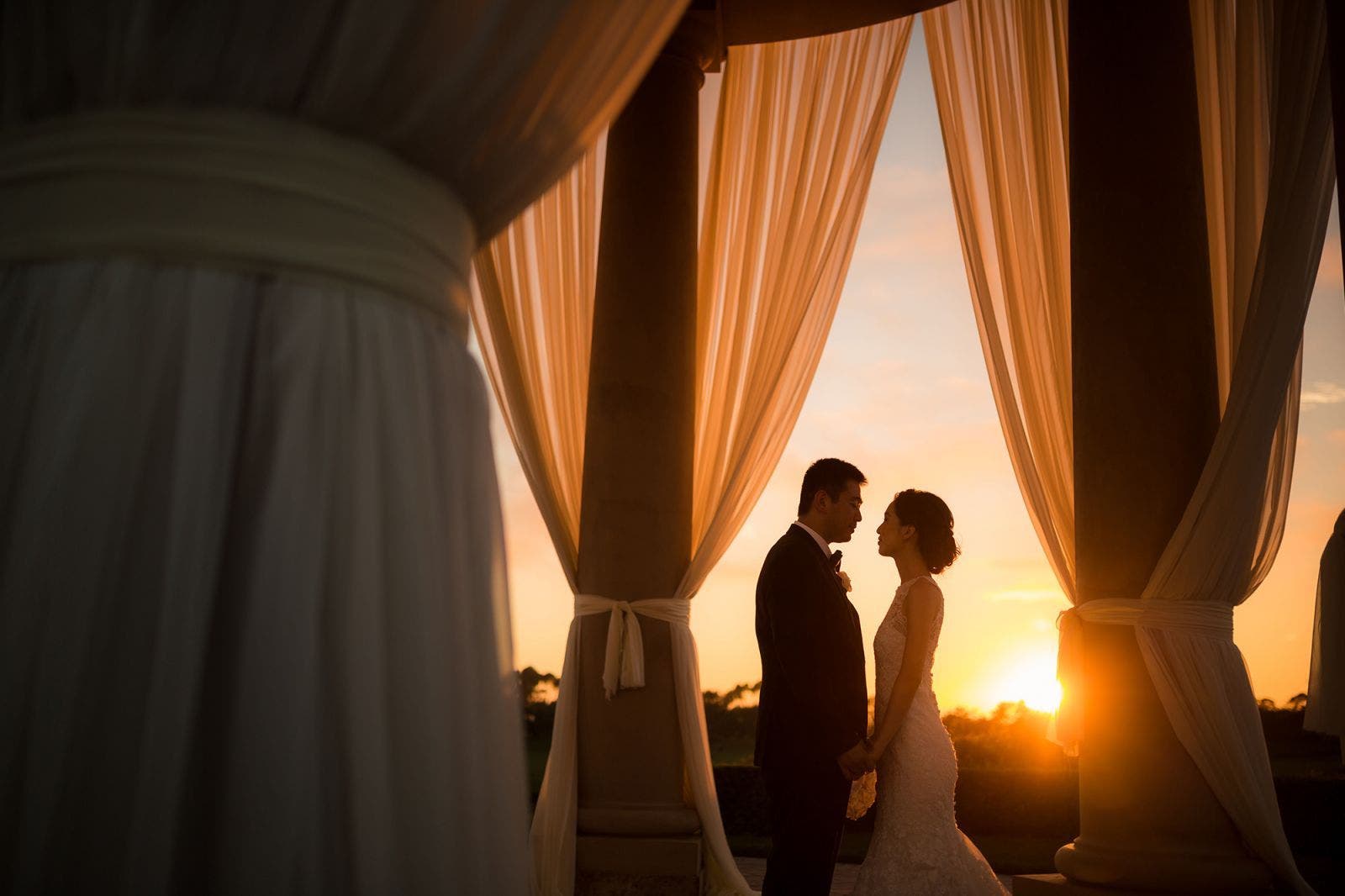 couple pose at sunset for silhouette photography