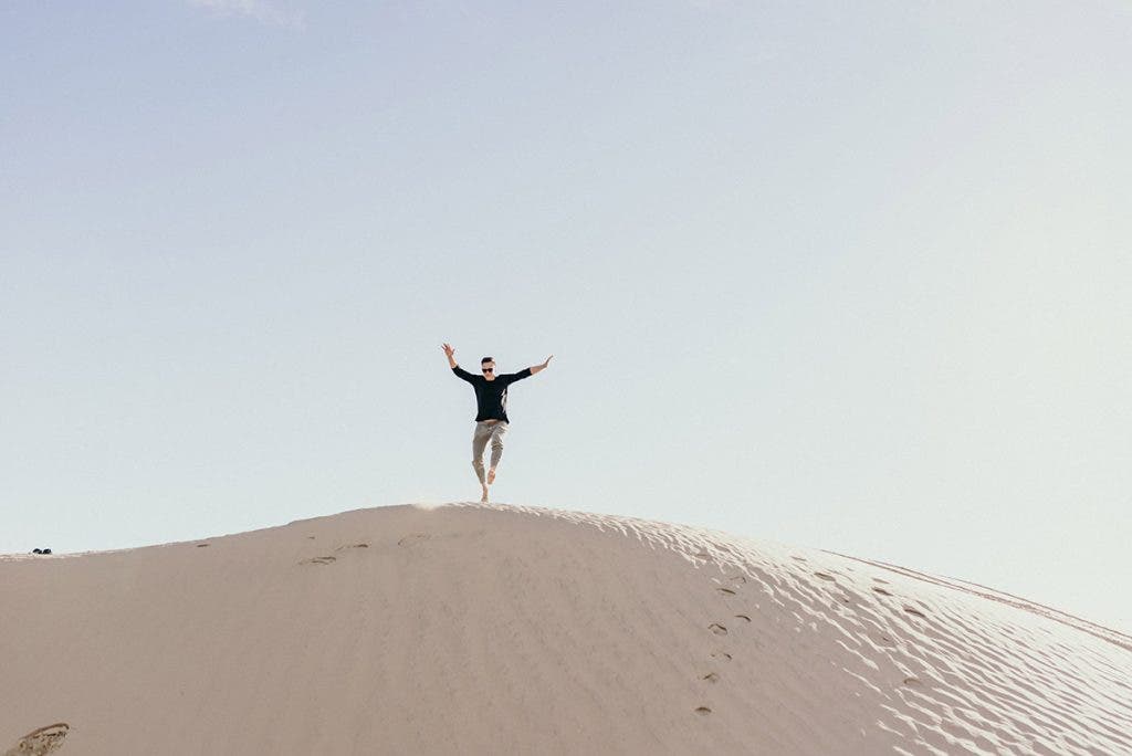 man running on sand dunes