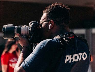 sports photographer doing sports photography with camera on soccer field