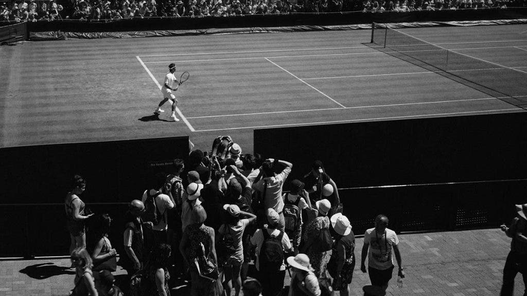 sports photographer doing sports photography with camera on tennis