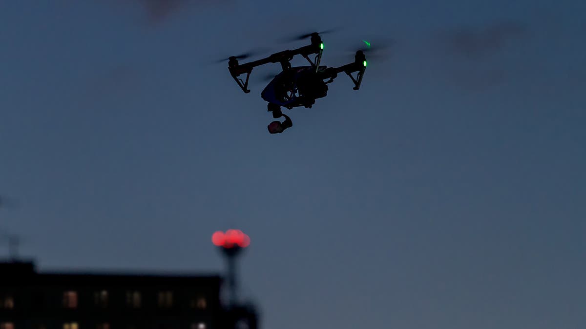 uas night operations drone flying at night over buildings in dark sky