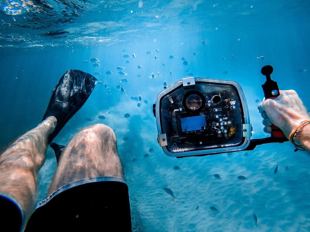 diver with underwater camera housing