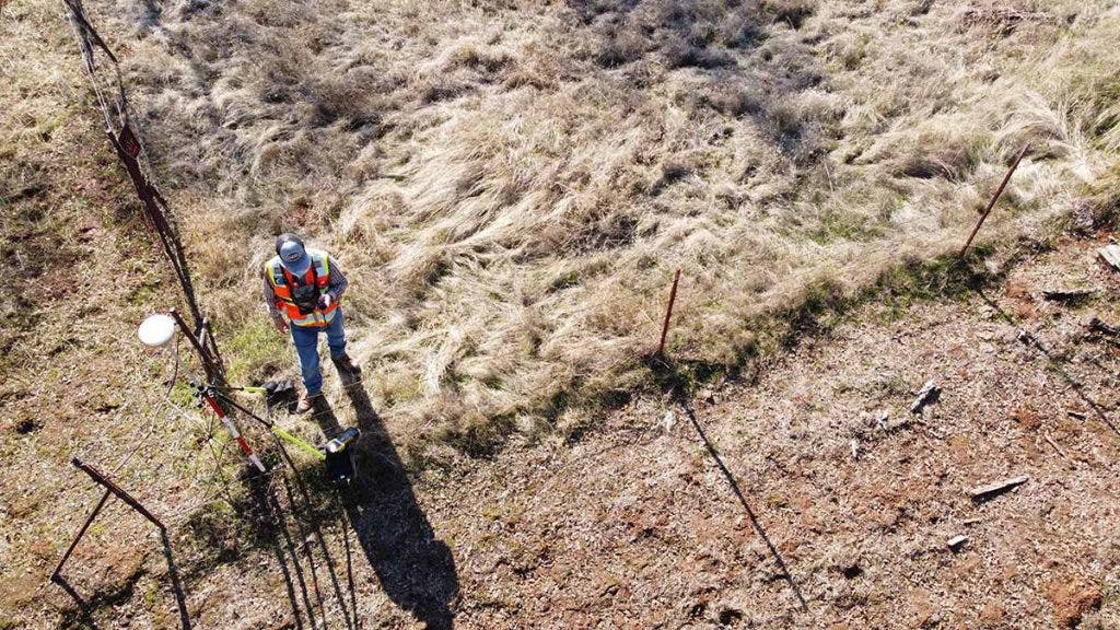 drone aerial shot of construction worker on field