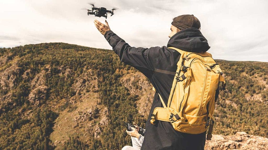 travel photographer creative flying a drone in mountains