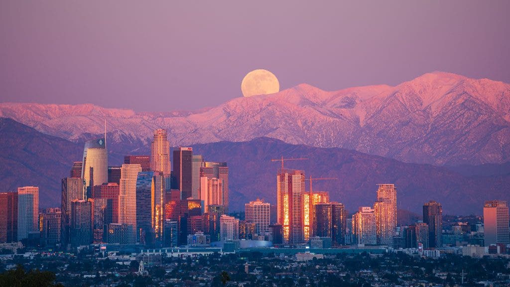 vibrant photography of moon over skyline