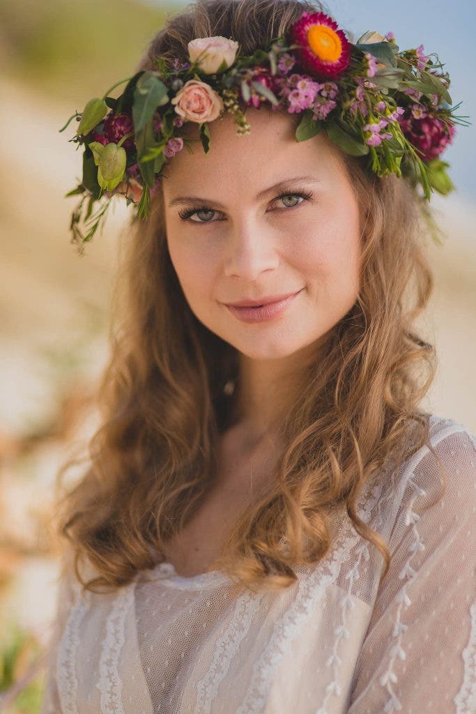 bride in flowers shows how to smile for pictures