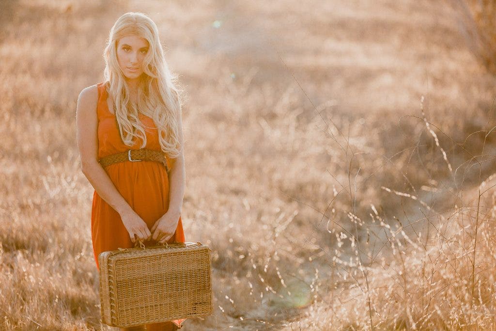 Girl stands in field for golden hour