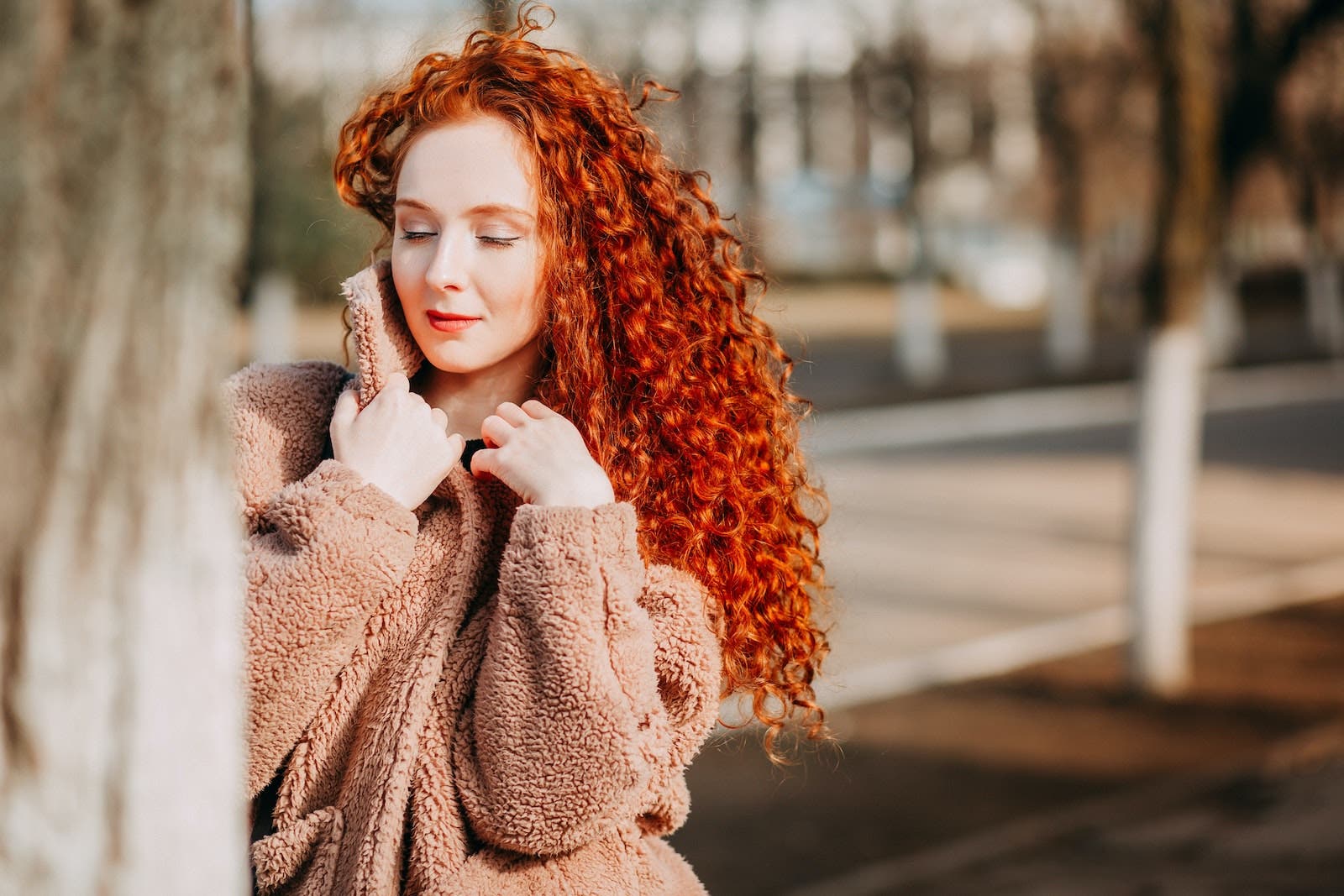 Girl with red hair by tree