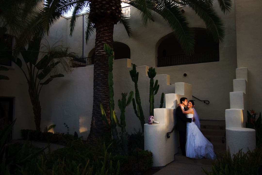 A couple is spot-lit in front of a hotel
