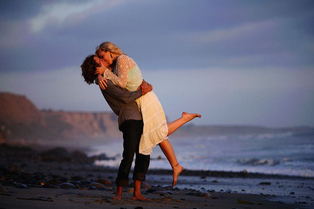 A couple kisses on the beach