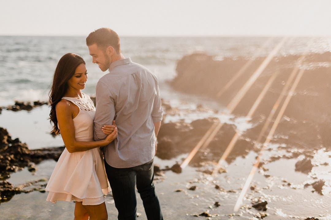 A couple stands under a light flare