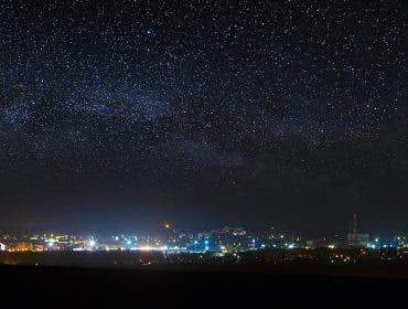 Panoramic view of the starry night sky above the city.