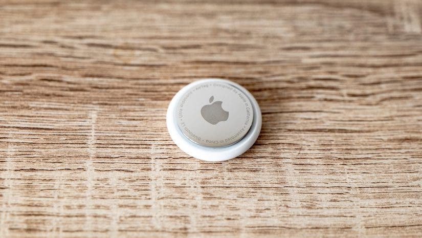 Apple AirTag tag on wooden surface for tracing lost items with copyspace on both sides