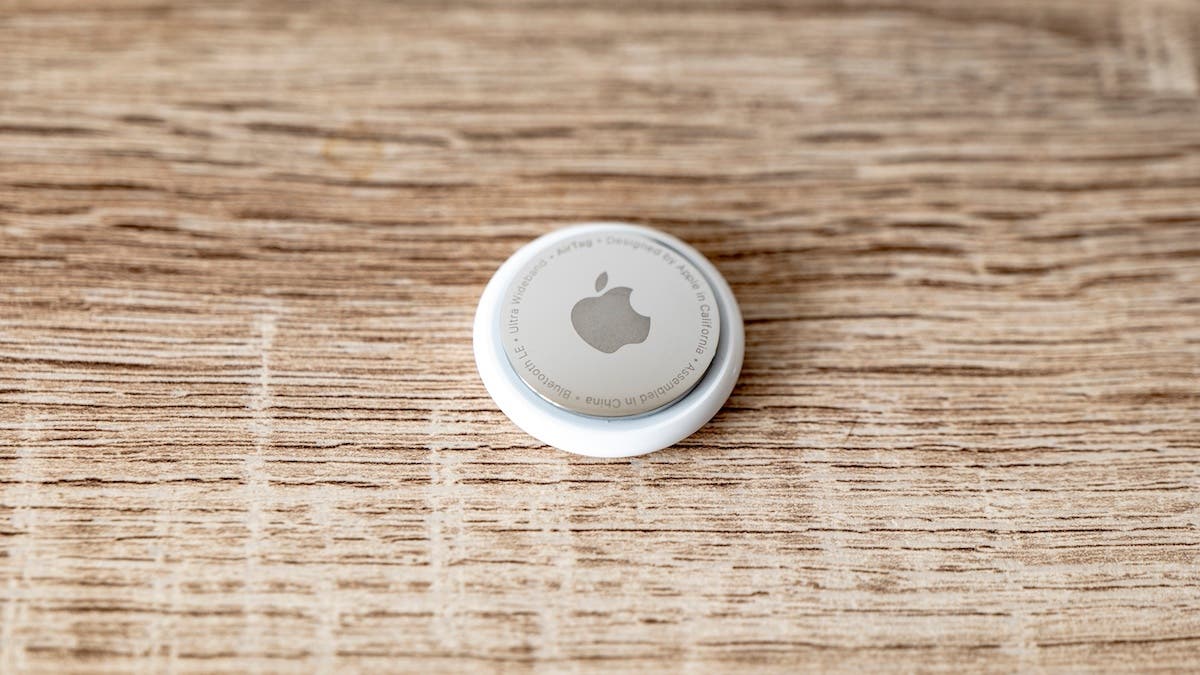 Apple AirTag tag on wooden surface for tracing lost items with copyspace on both sides