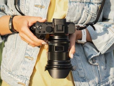 Digital mirrorless camera with a lens in the girl's hands, close-up photo. High quality photo