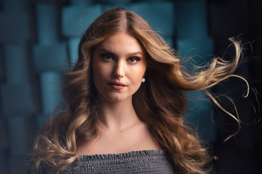 When deciding How to choose the best camera for portraits there are many factors to consider such as sensor size. This portrait of a female model with her hair blowing was shot with a micro-four-thirds sized sensor.